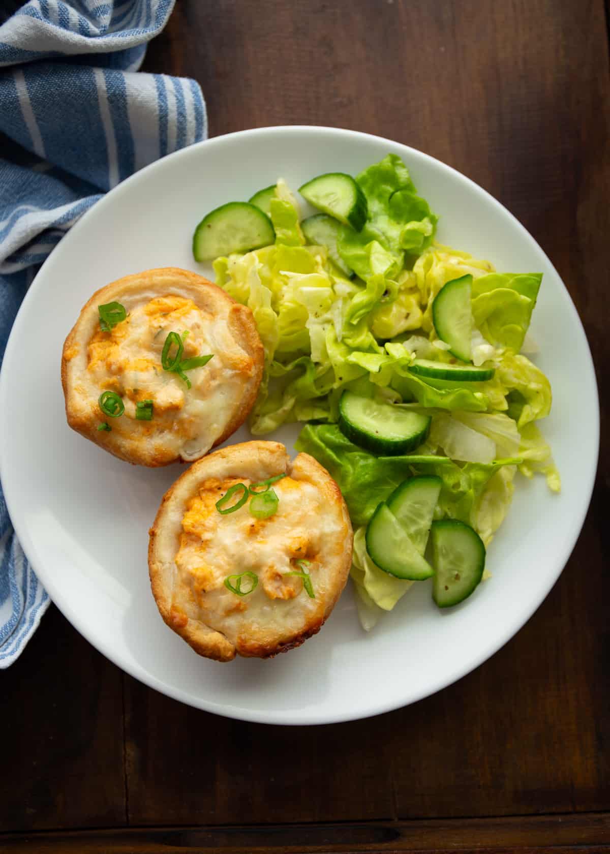 overhead image of buffalo chicken bites and salad on a white plate