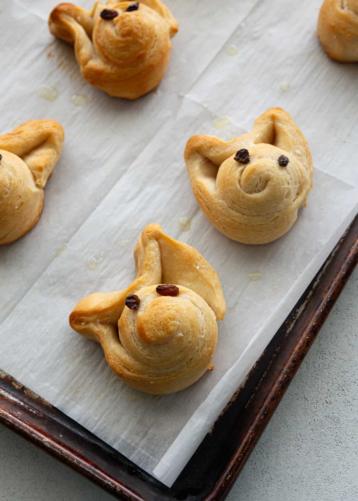 overhead image of cooked bread bunnies on a parchment lined sheet pan