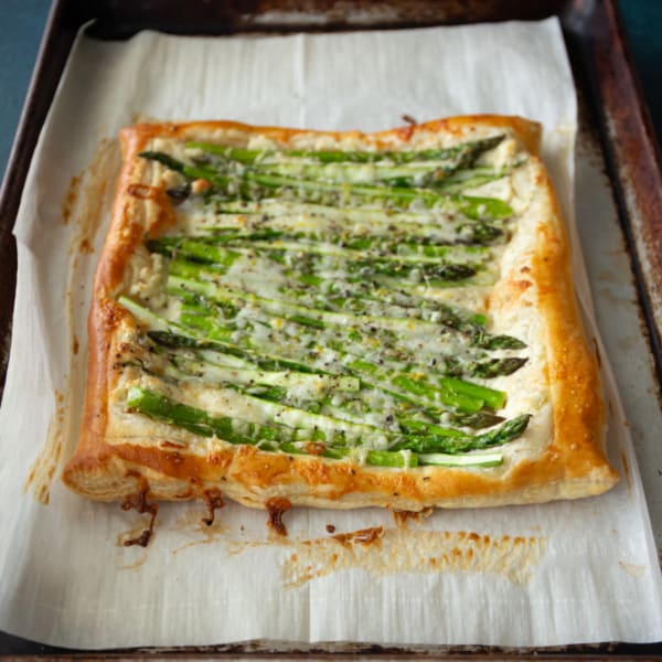 asparagus puff pastry on a parchment lined sheet pan