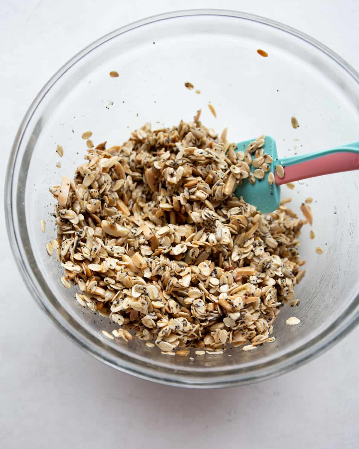 overhead image of granola mixture in a clear glass bowl