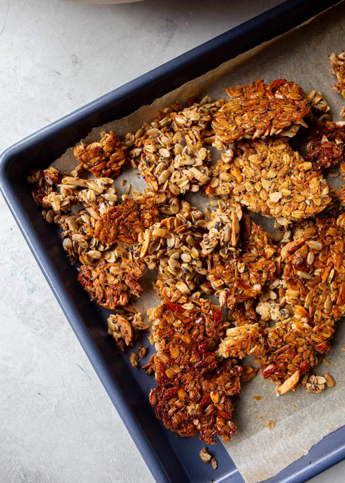 cooked granola on a parchment lined sheet pan