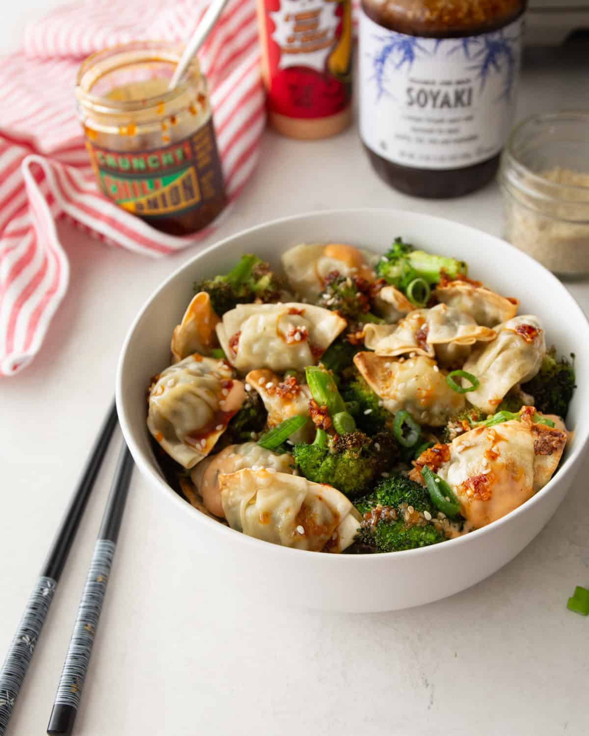potstickers and broccoli in a white bowl on a white table