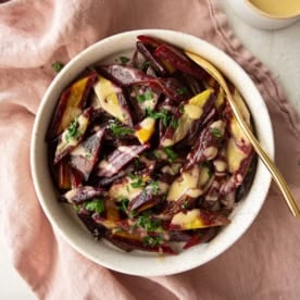 overhead image of purple carrots in a white bowl