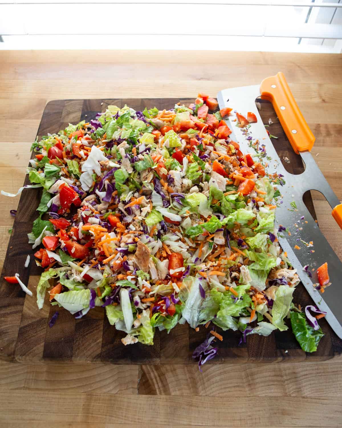 chopped chicken salad on a wooden cutting board