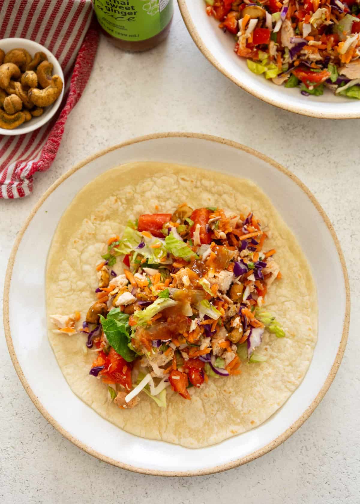 overhead image of chopped chicken salad on a flour tortilla on a white plate