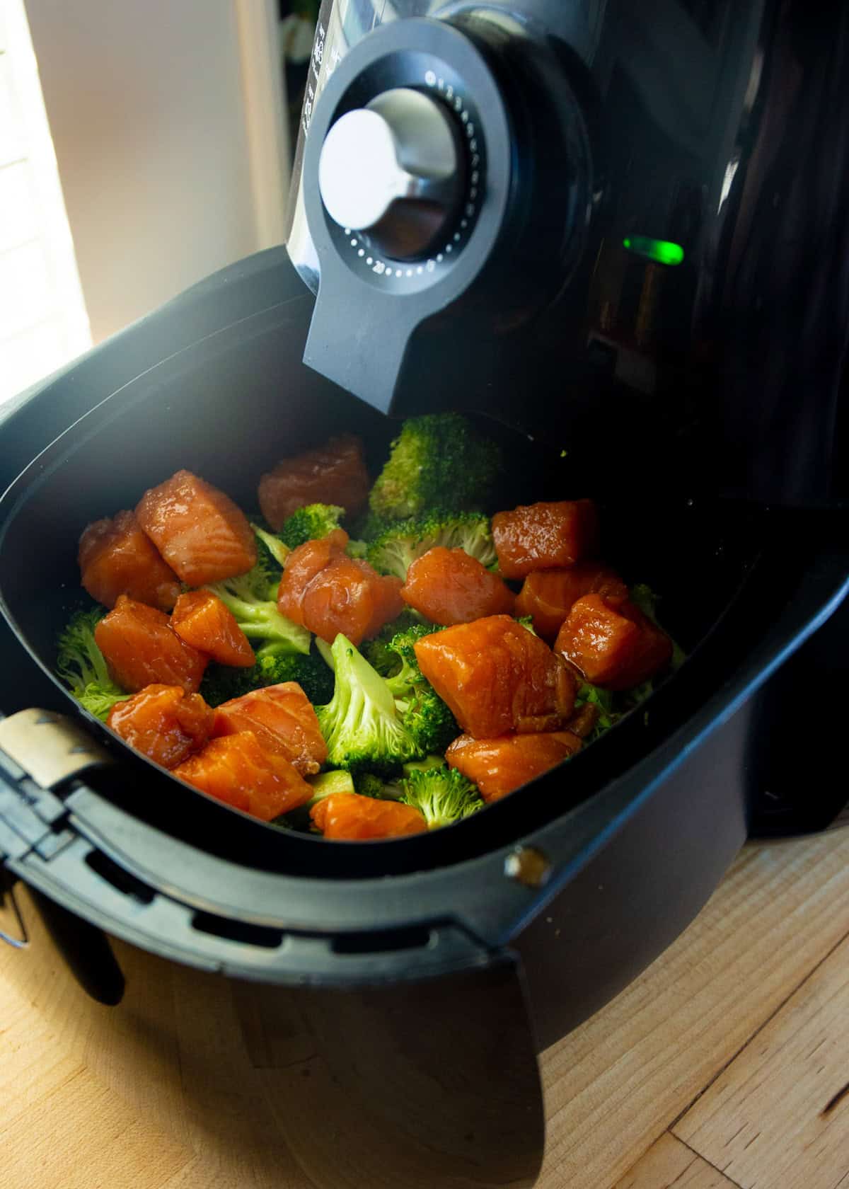 raw salmon and broccoli in the air fryer