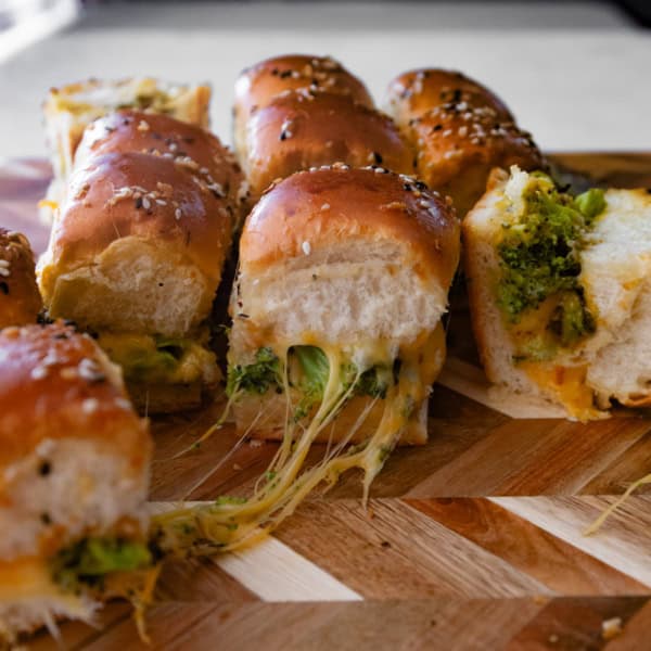 broccoli and sliders on a wood cutting board