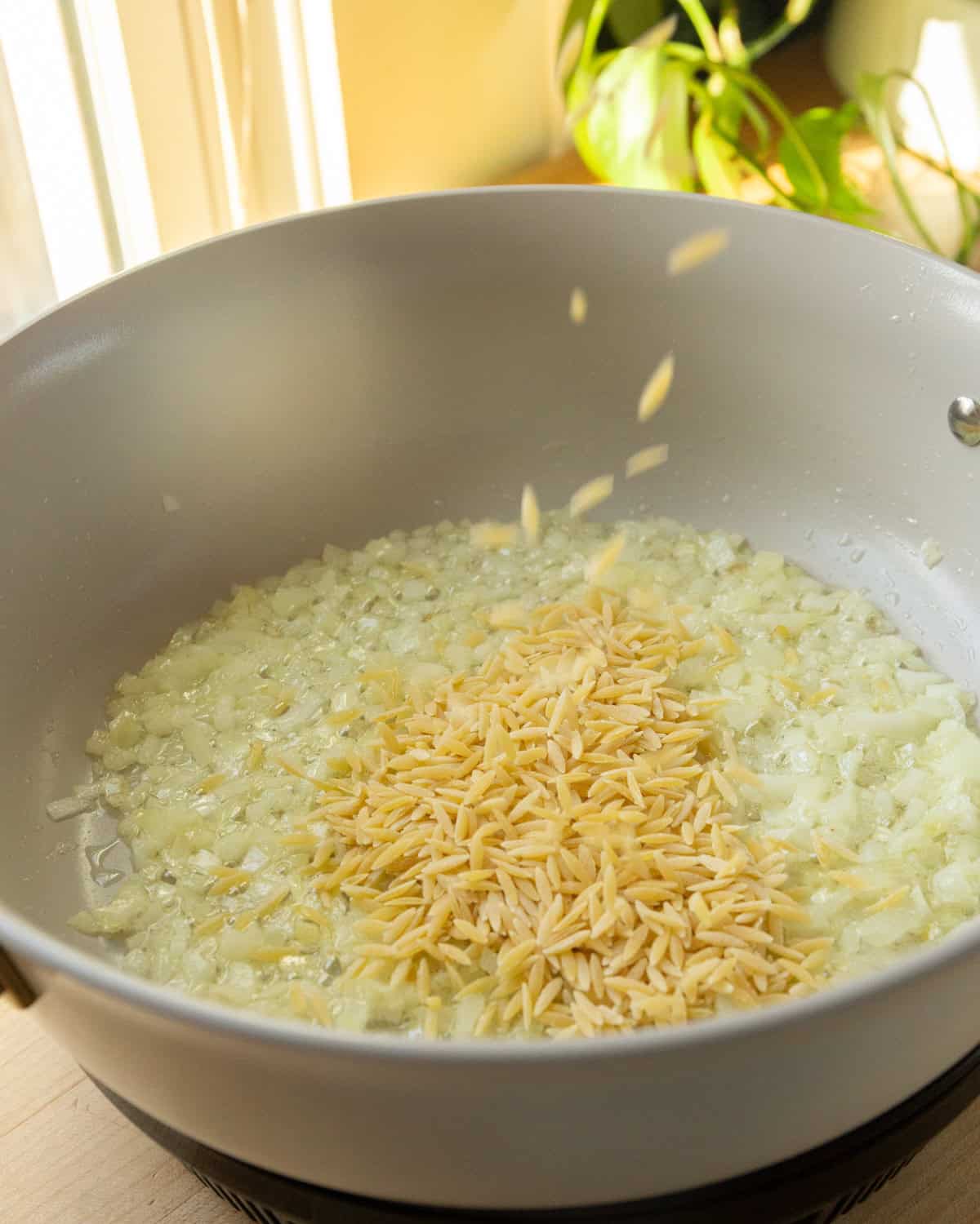 adding orzo to cooking onions
