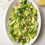 overhead image of butter lettuce salad on a white oval platter