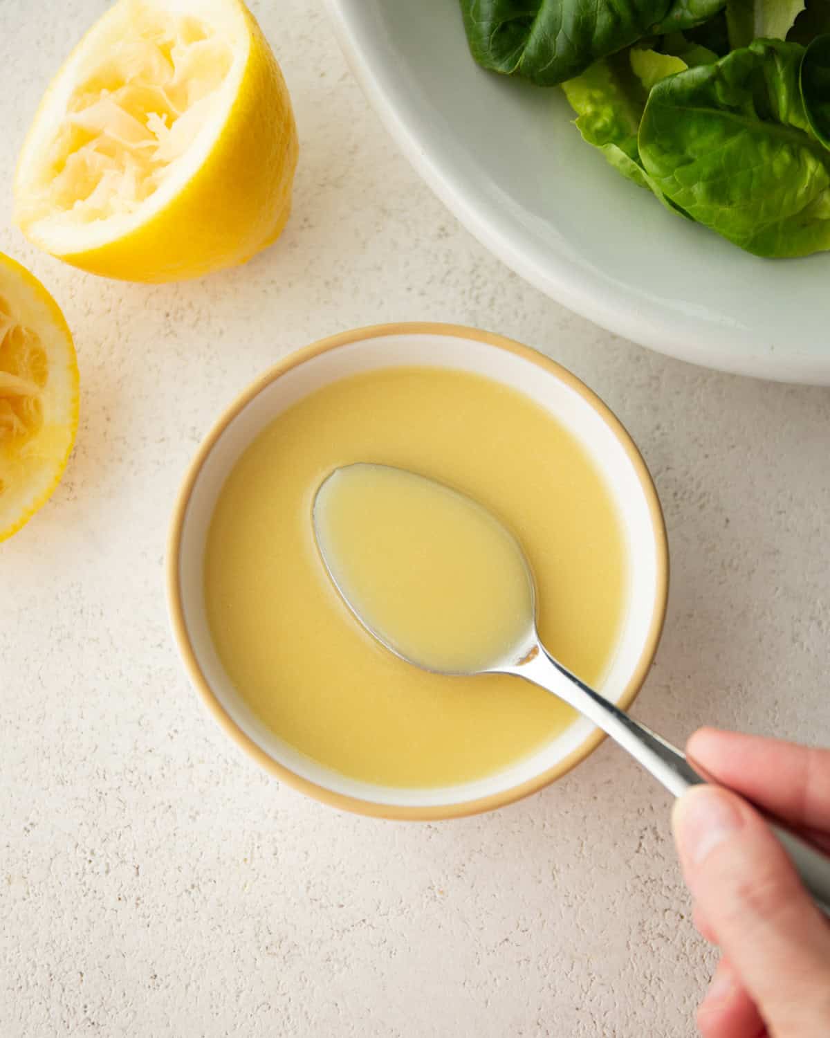 overhead image of lemon vinaigrette in a small with bowl with a spoon