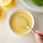 overhead image of lemon vinaigrette in a small white bowl with a spoon