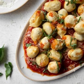 air fryer stuffed gnocchi and marinara sauce on an oval platter