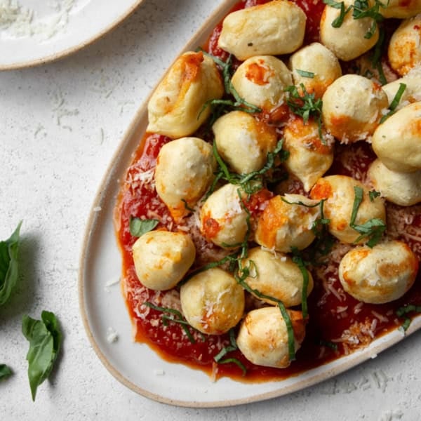 air fryer stuffed gnocchi and marinara sauce on an oval platter
