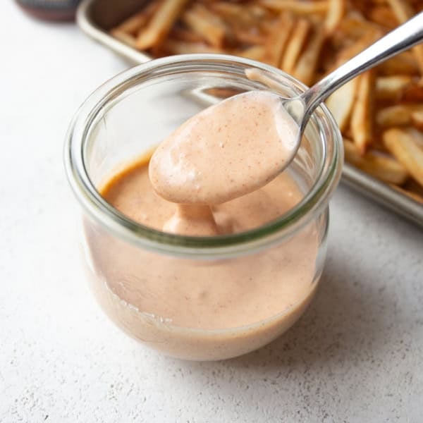a spoon in a small jar of yum yum sauce