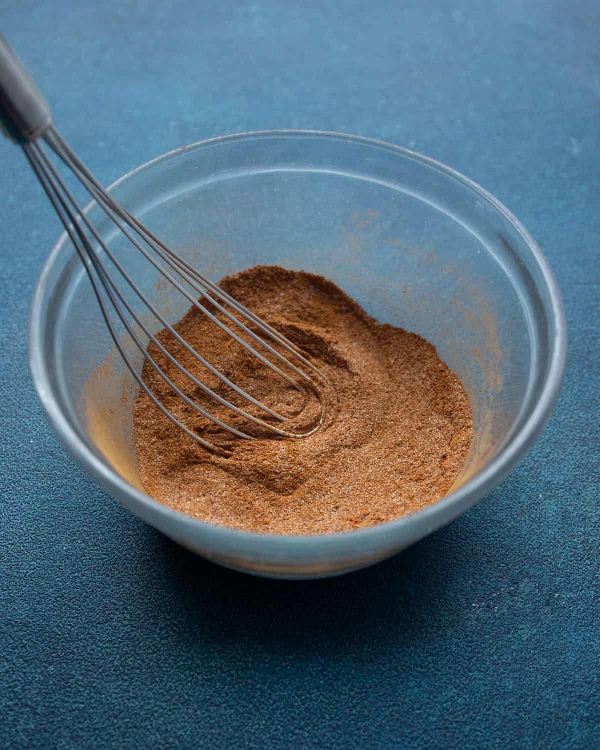 stirring cinnamon sugar in a clear bowl