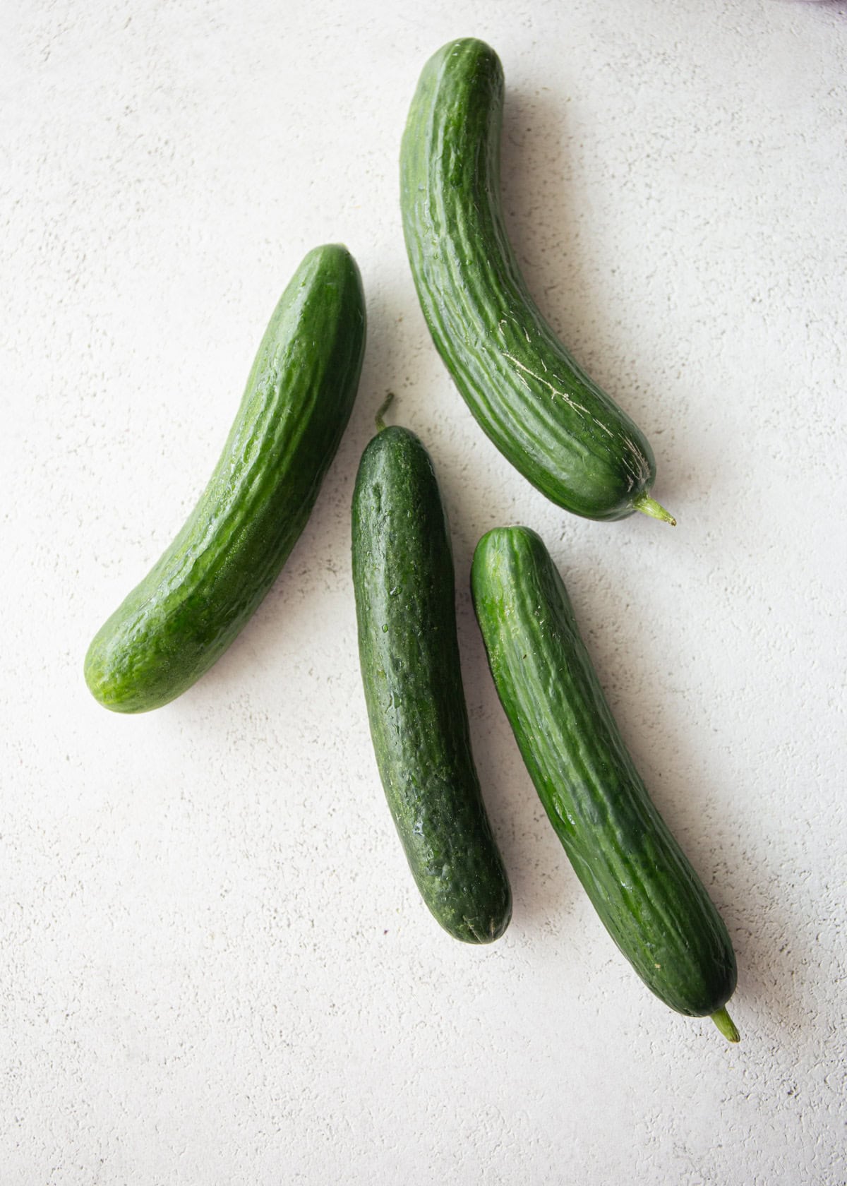 overhead image of cucumbers on a white countertop