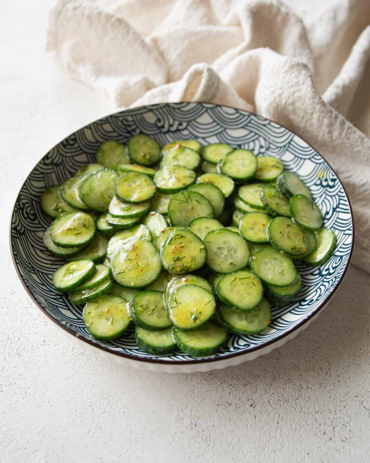 cucumber salad in a white and blue bowl