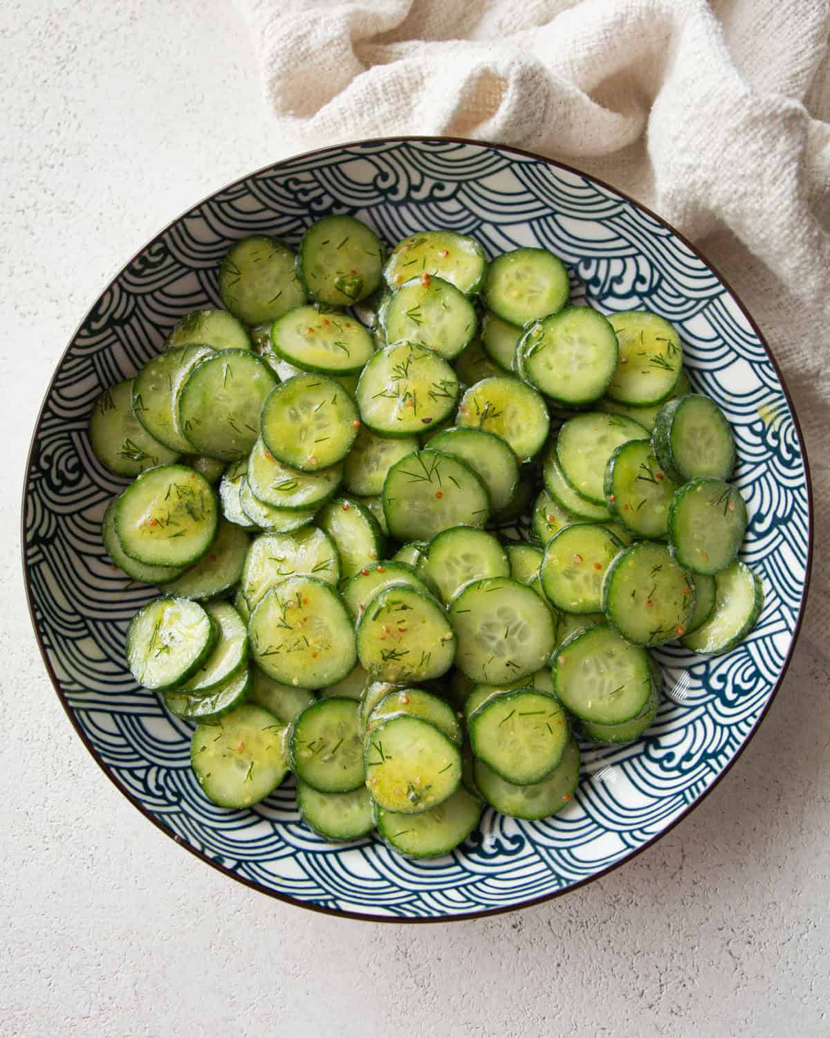 overhead image of cucumber salad in a blue and white bowl