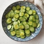 overhead image of cucumber salad in a blue and white bowl