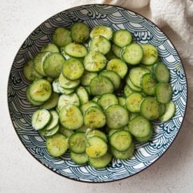 overhead image of cucumber salad in a blue and white bowl