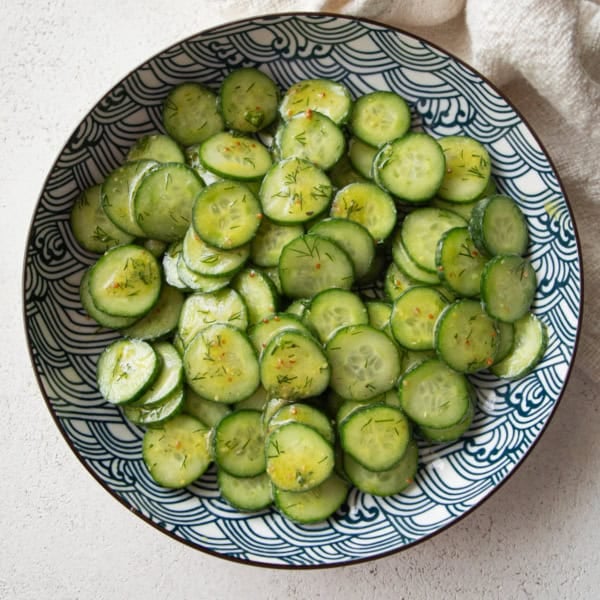overhead image of cucumber salad in a blue and white bowl