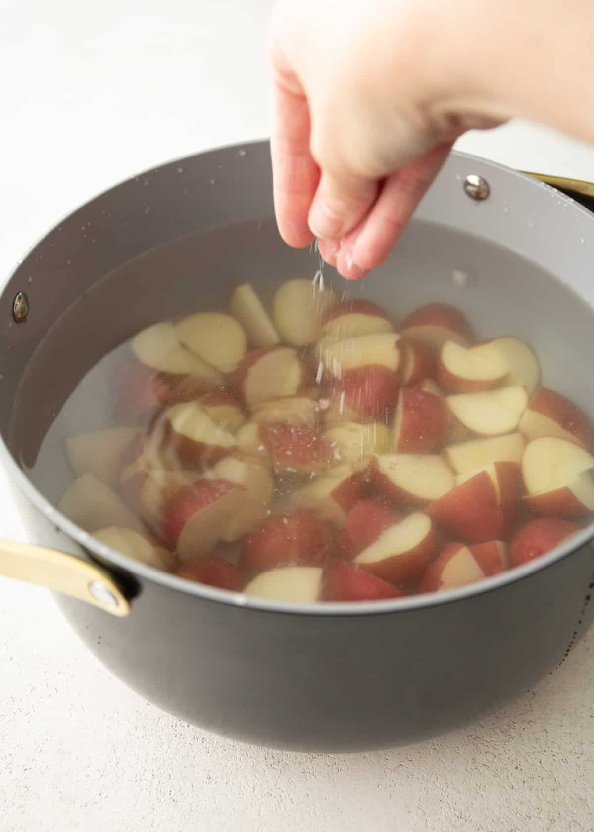 salting potatoes in a pot of water