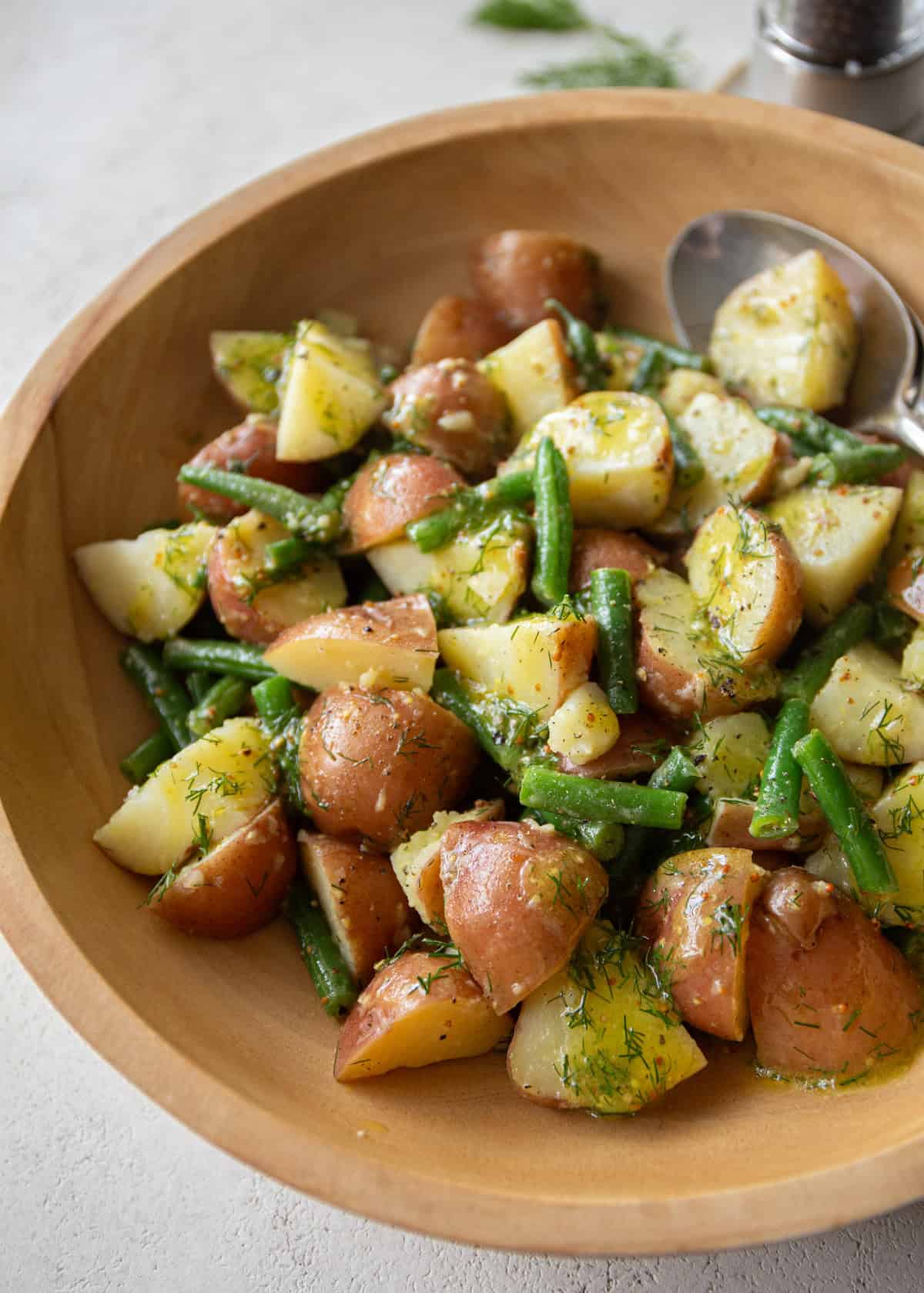 green bean and potato salad in a wooden bowl 