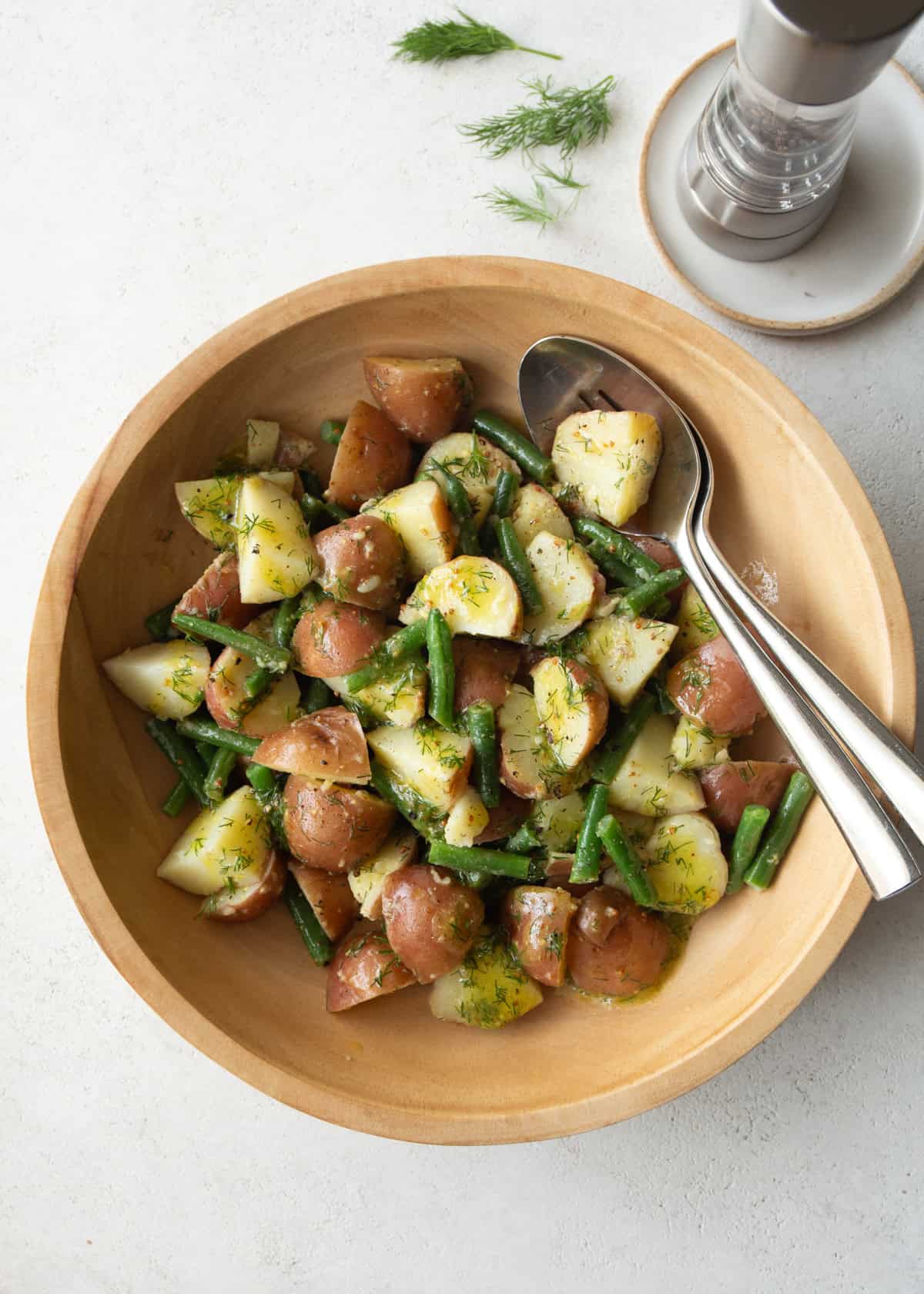 overhead image of green bean and potato salad in a wooden salad bowl