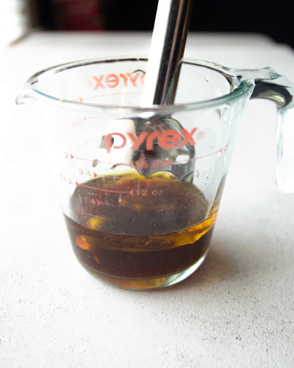 using an immersion blender in a large glass measuring cup