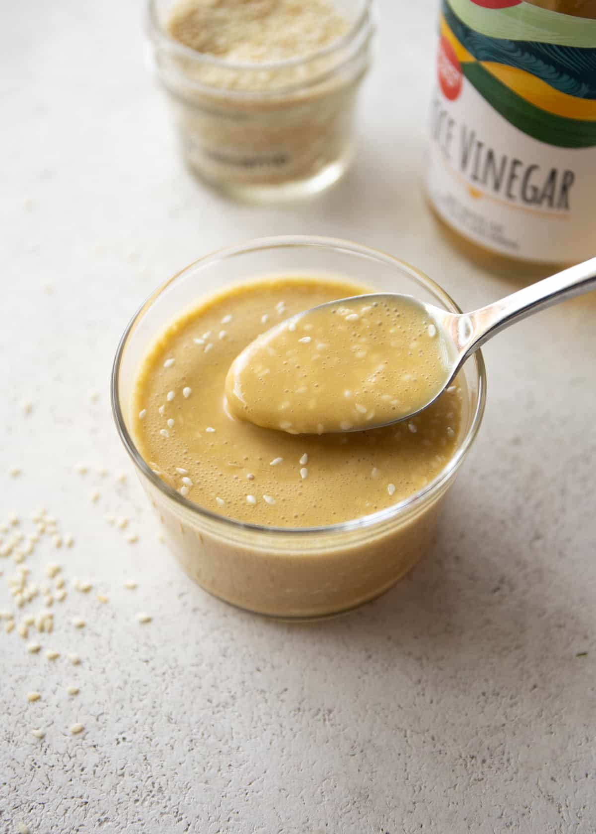 a spoon in a small jar of miso salad dressing