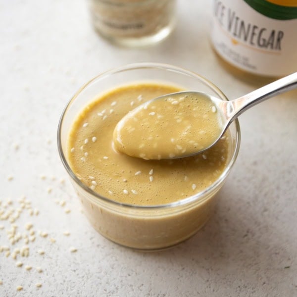 a spoon in a small ramekin of miso dressing