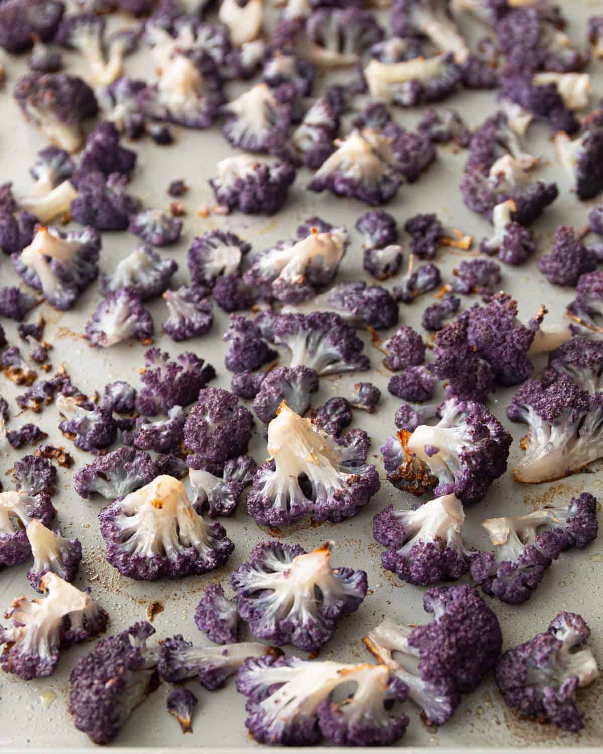 roasted purple cauliflower florets on a sheet pan