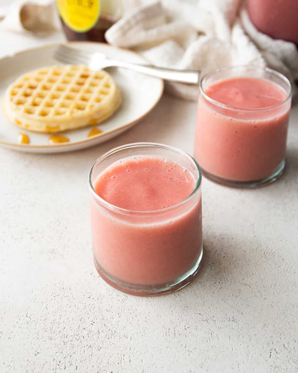 smoothies in small glasses on a white countertop