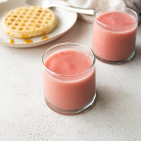 smoothies in small glasses on a white countertop