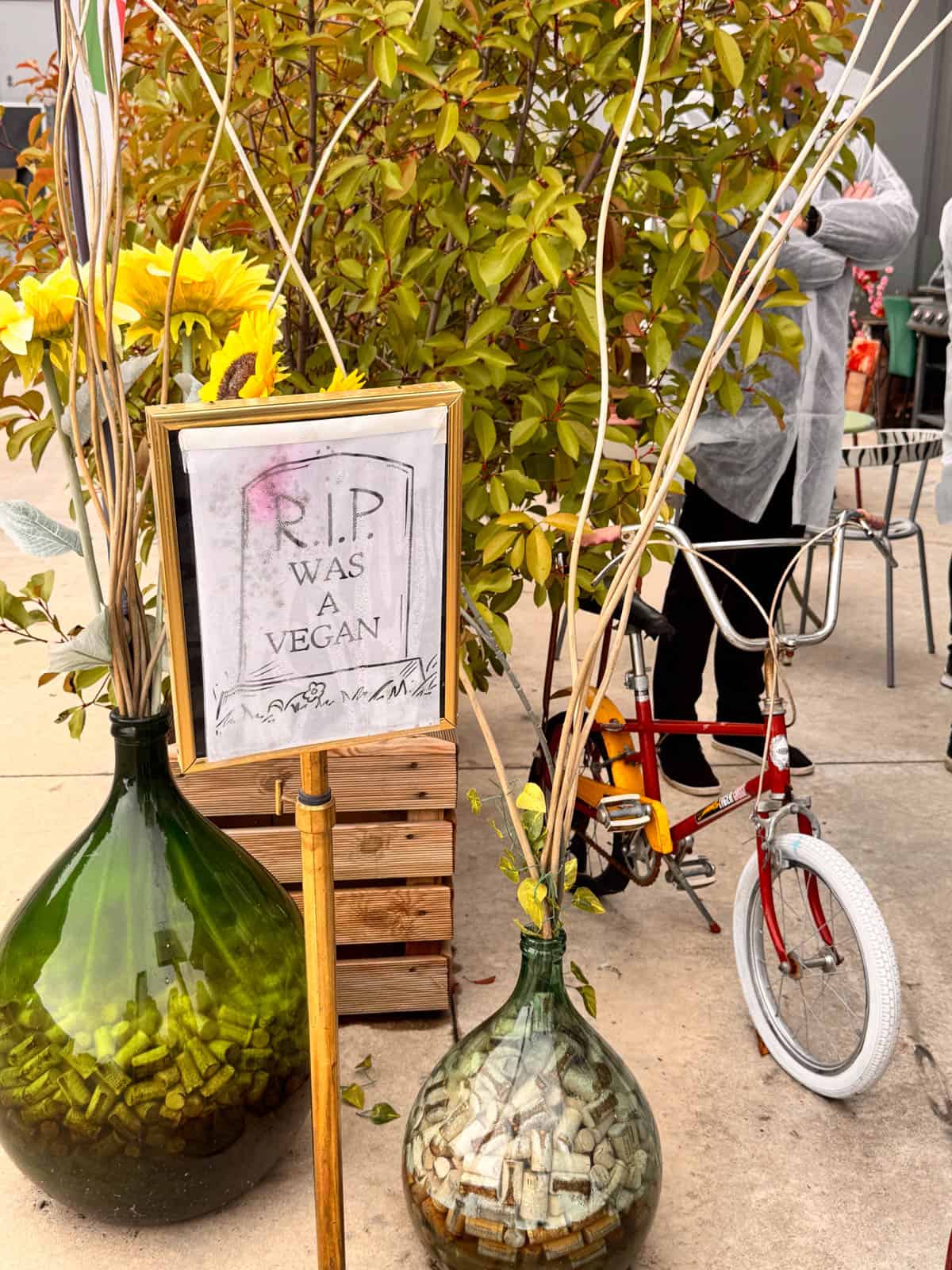 a sign outside of a prosciutto factory that says "RIP was a vegan"