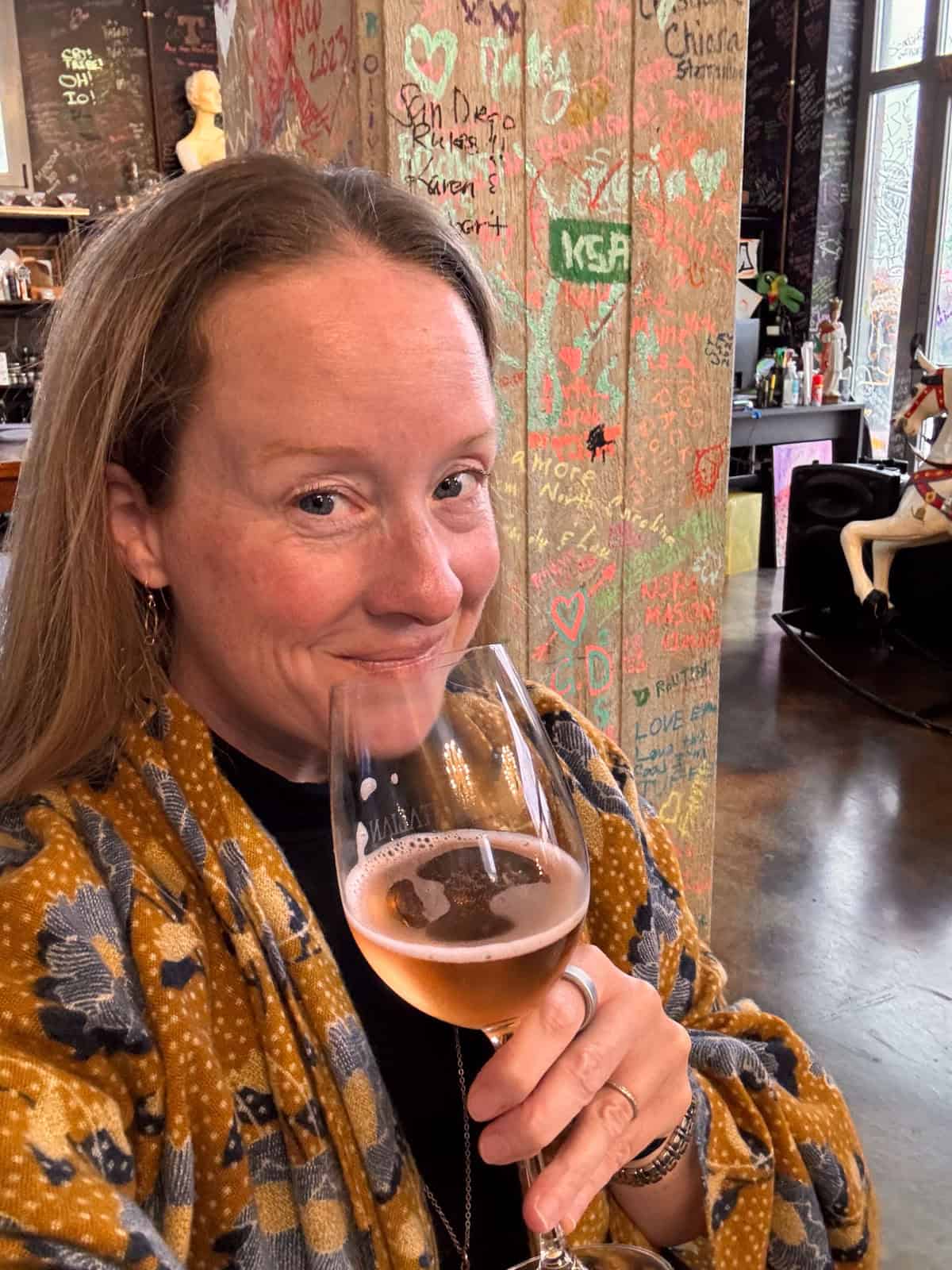 Jess sipping a glass of pink wine